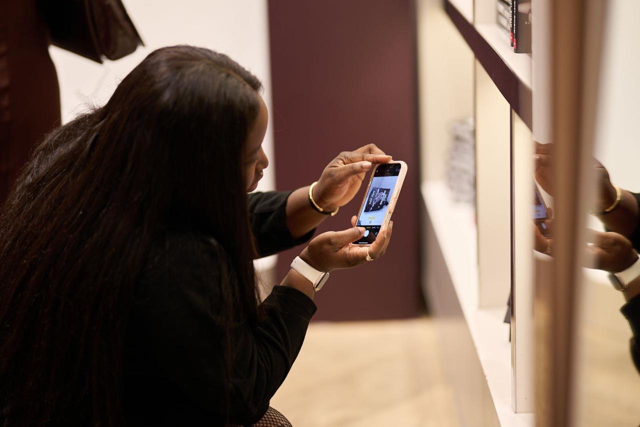 Tofunmi Balogun photographing an exhibit up close on her phone